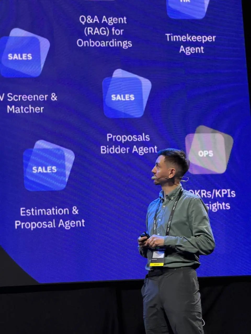 Roman in front of a slide of AI agents for sales, HR and delivery.